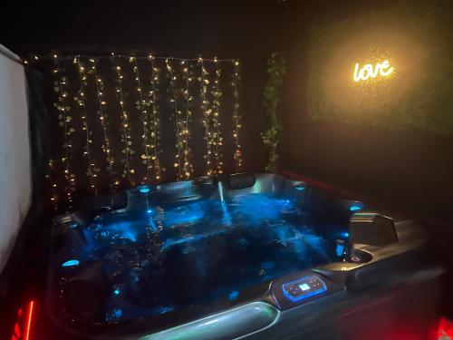 a hot tub in a room with a sign that says love at Homelove Spa in Neuilly-en-Thelle