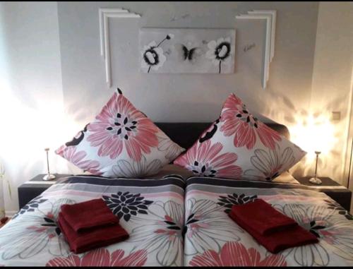 a bed with red and white pillows on it at Apartment Bella Italia in Cologne