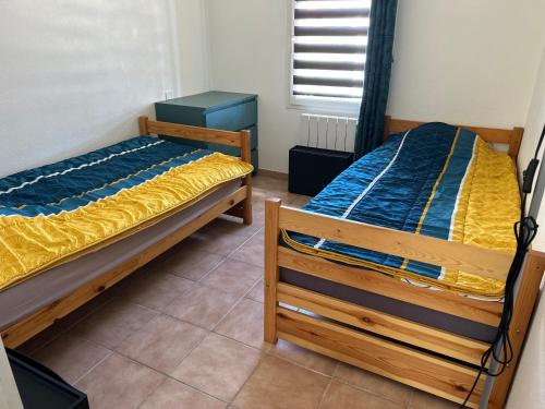 deux lits jumeaux dans une chambre avec fenêtre dans l'établissement Villa Roussillon, à Torreilles