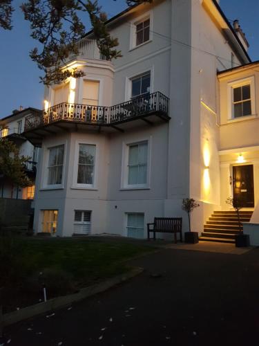 a white building with a bench in front of it at 4 Sea View in Ryde