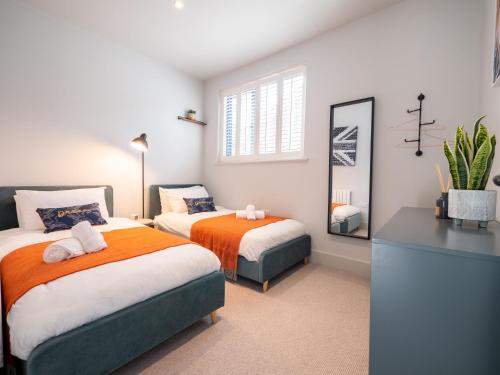 a bedroom with two beds and a mirror at Redwalls Luxury House in Dartmouth