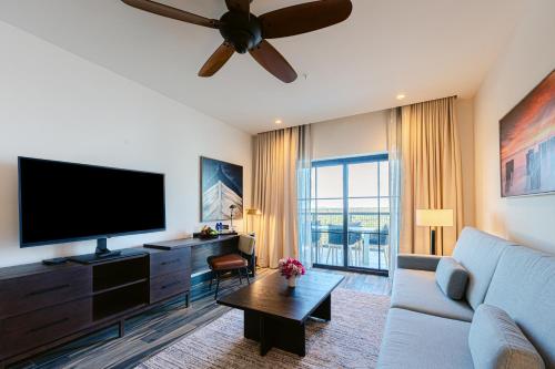 a living room with a couch and a flat screen tv at The Perry Hotel Naples in Naples