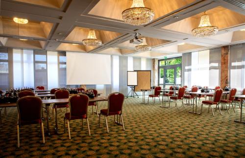a conference room with tables and chairs and a projection screen at SOALTEE Hotel by Trip Inn Frankfurt Messe Tagungshotel in Frankfurt/Main