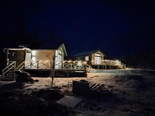 a cabin in the snow at night with lights at Magisch berghuisje met uitzicht op Nationaal Park Fulufjället in Sörsjön
