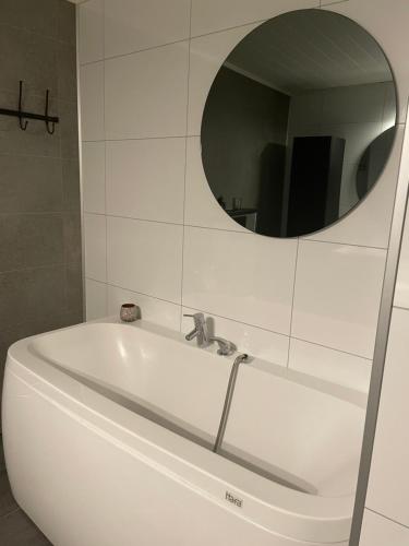 a white tub in a bathroom with a mirror at Fageråsen terrasse in Mo i Rana