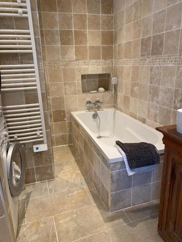 une salle de bain avec baignoire et machine à laver dans l'établissement Villa Les Planches proche Place Morny, à Deauville