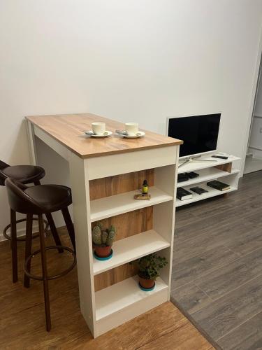 a kitchen island with a table and chairs and a television at Светлая 2 спальная квартира в историческом центре Астаны in Astana