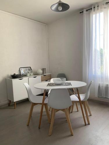 une salle à manger avec une table et des chaises blanches dans l'établissement Cozy apartment near Aix-en-Provence, à La Celle-sous-Gouzon