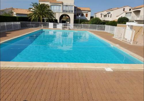 une grande piscine avec de l'eau bleue dans l'établissement Maison soleil d'or proche mer, à Vaux-sur-Mer
