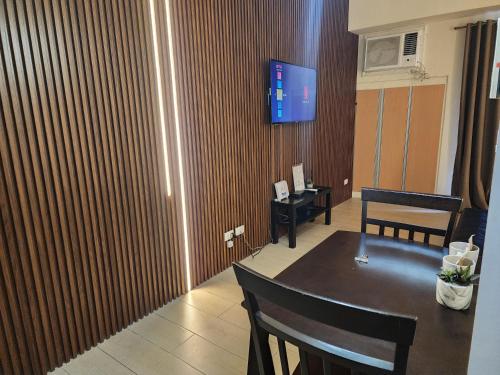 a room with a table and a tv on a wall at palm tree villas in Manila