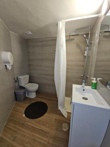 a bathroom with a white sink and a toilet at Blue Mango Surf House Center in Puerto del Rosario