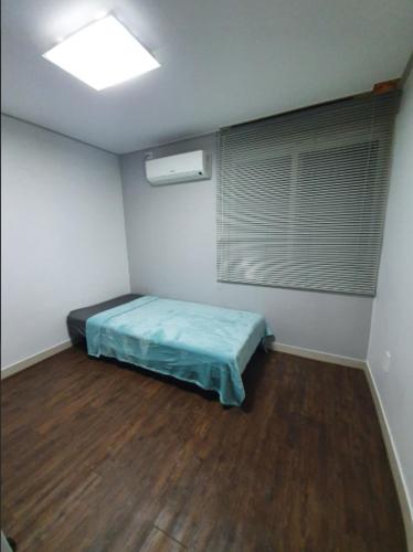 a small room with a bed and a window at Residence Stay Avenu in Ulsan