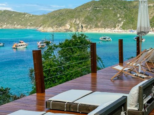 a deck with chairs and a view of the water at Hotel Recanto do Atalaia in Arraial do Cabo