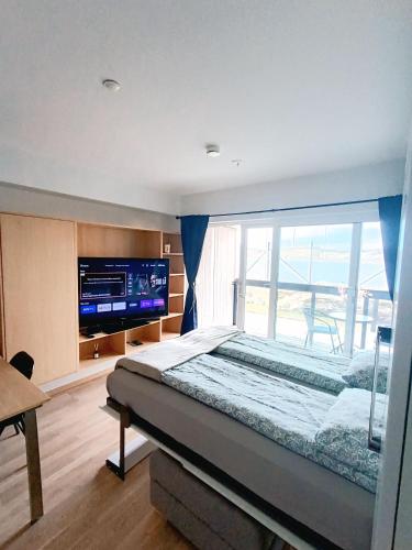 a bedroom with a large bed and a large window at Panoramisk leilighet(nær flyplass) in Bodø