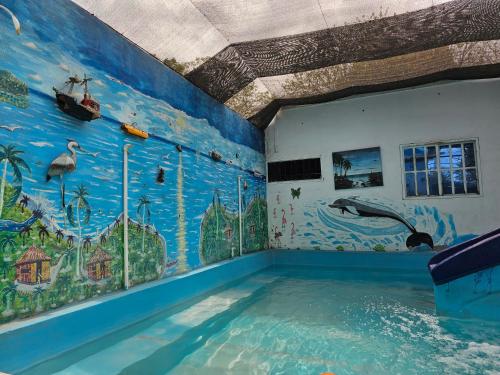 圣玛尔塔Oh la la的墙上挂有壁画的游泳池