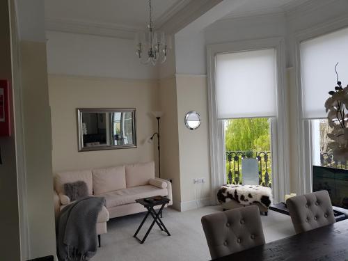 a living room with a couch and a mirror at 4 Sea View in Ryde