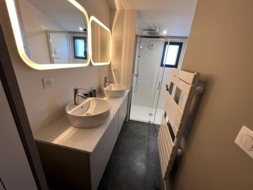 a bathroom with two sinks and a mirror at Villa La Bosse Ile de Noirmoutier pour 10 personnes in LʼÉpine