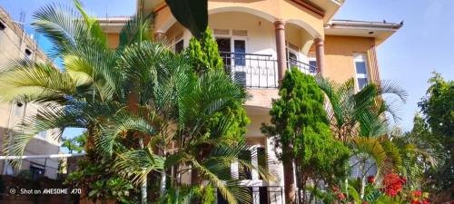 a building with palm trees in front of it at Rogerzi in Bwerenga
