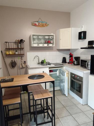 - une cuisine avec des appareils blancs, une table et des chaises dans l'établissement Studio 500m plage, à La Tranche-sur-Mer