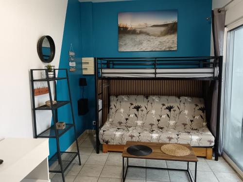 - une chambre avec des lits superposés aux murs bleus dans l'établissement Studio 500m plage, à La Tranche-sur-Mer