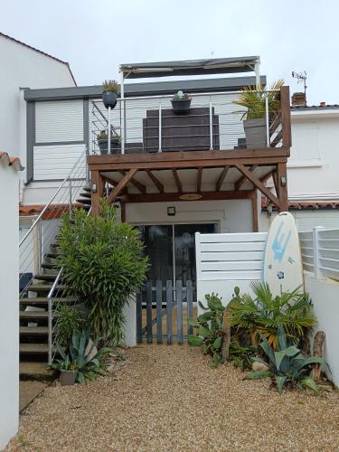une maison avec un balcon muni d'une planche de surf dans l'établissement Studio 500m plage, à La Tranche-sur-Mer