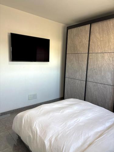 a bedroom with a bed and a flat screen tv at אירוח אריאל in Hagoshrim