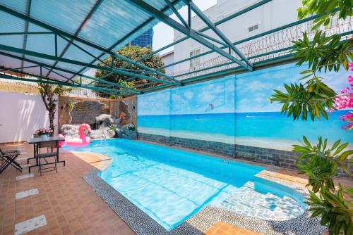 an indoor swimming pool with a large glass wall at Kegotel Villa Bãi Sau ngay Tháp Tam Thắng in Vung Tau