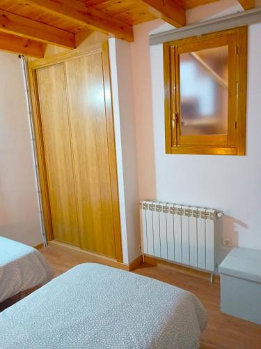 a bedroom with two beds and a wooden cabinet at A Casa da Boa Xente VUT-OU-1329 in Verín