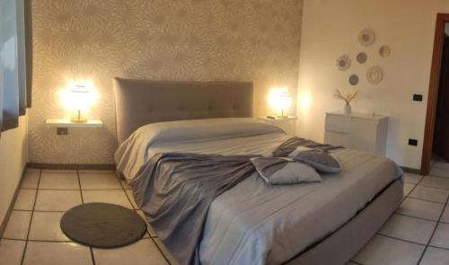 a bedroom with a large bed with two lamps at Donna Rosa in Pagani