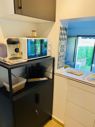 une cuisine avec un four micro-ondes au-dessus d'un comptoir dans l'établissement Villa Club Mer Belle, à Sanary-sur-Mer