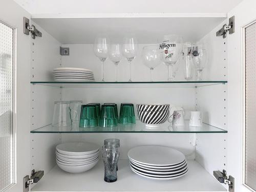 a cupboard filled with glasses and plates and dishes at Appartement 2 personnes - Stade rugby Yves du Manoir in Montpellier