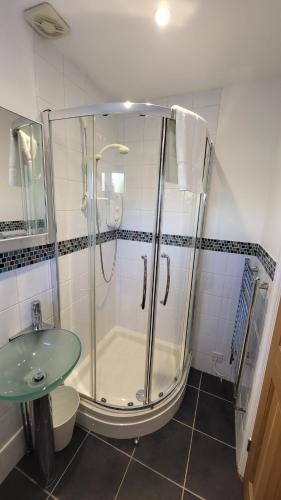 a bathroom with a shower and a toilet and a sink at Home for one! in Midford