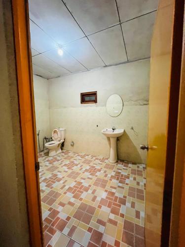a bathroom with a toilet and a sink at Sinharaja Retreat in Deniyaya