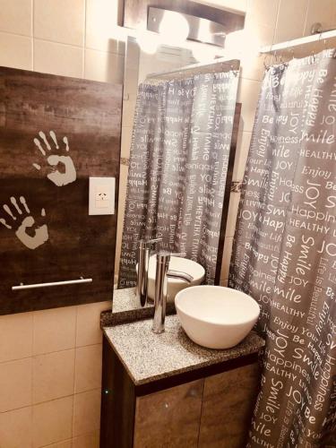 a bathroom with a sink and a counter with a mirror at Monoambiente en complejo privado con Piscina en microcentro - Excelente Ubicacion in San Juan