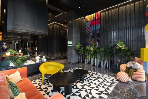 a man sitting on a couch in a lobby at Premium Collins Boulevard Near Airport in Pakulonan Tiga