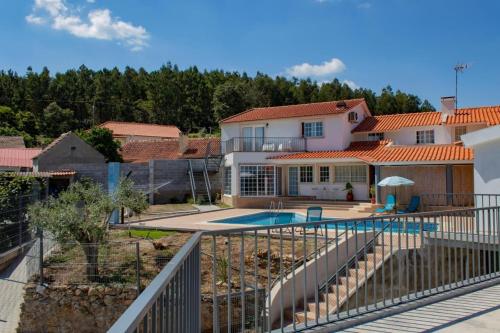 a villa with a swimming pool and a house at Casa do Largo in Figueiró dos Vinhos