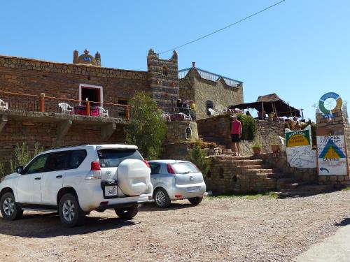 deux voitures garées devant un bâtiment en briques dans l'établissement Auberge Amazigh, à Tamtetoucht