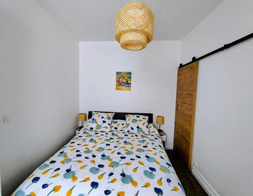 een slaapkamer met een bed en een kroonluchter bij escapade à Wimereux in Wimereux