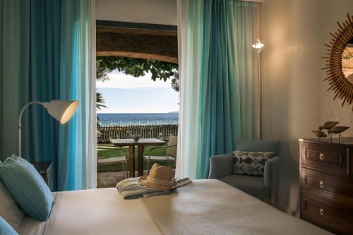 a bedroom with a bed and a view of the ocean at La Pinède Plage in La Croix-Valmer