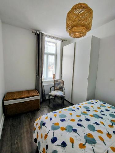 une chambre avec un lit, une chaise et une fenêtre dans l'établissement escapade à Wimereux, à Wimereux