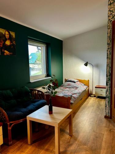 a living room with a bed and a coffee table at Sloneczny pokoj in Świnoujście