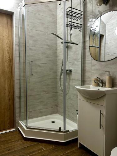 a shower with a glass door next to a sink at Sloneczny pokoj in Świnoujście
