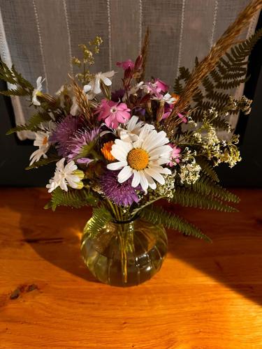 un vase rempli de fleurs posé sur une table dans l'établissement Gîte Creusois, à Saint-Avit-de-Tardes