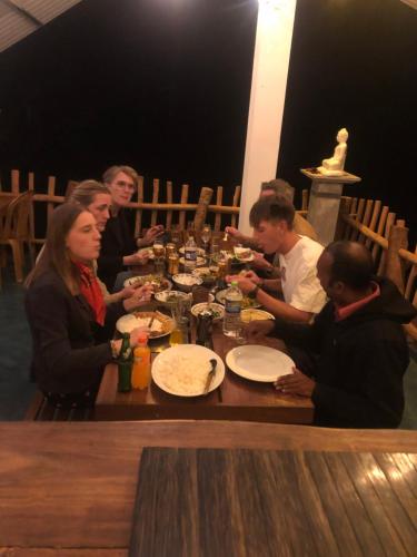 a group of people sitting around a table eating at Eagle View villa in Ella