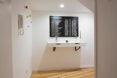 een witte muur met een witte tafel aan de muur bij Casa do Castelo 1- Work or Relax in the Historic heart of Lisbon! in Lissabon