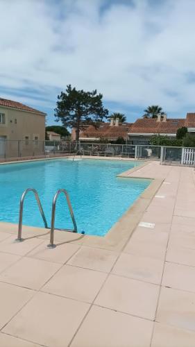 une piscine avec de l'eau bleue dans un immeuble dans l'établissement Villa club, à Sanary-sur-Mer