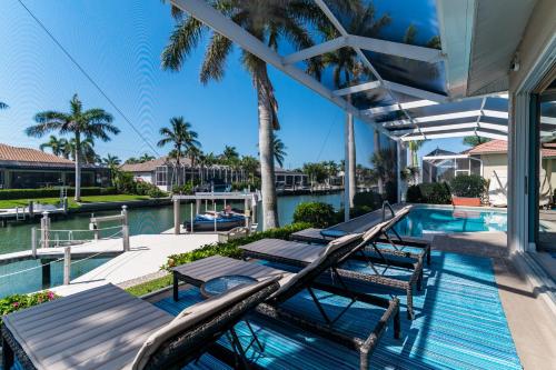 a swimming pool with chaise lounges on a house at New Listing Updated Waterfront I Walk to Beach in Marco Island