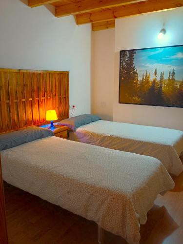 two beds in a room with a picture on the wall at A Casa da Boa Xente VUT-OU-1329 in Verín