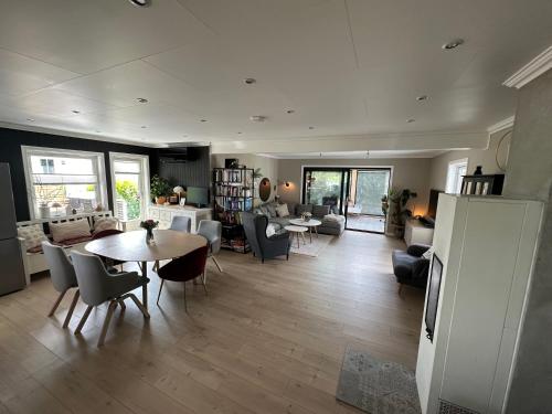 a large living room with a table and chairs at Modern large house in Stavern with sea view, close to beaches, large garden and pool in Larvik