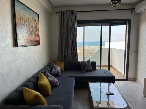 a living room with a couch and a glass table at Ocean park zenata in Aïn Harrouda